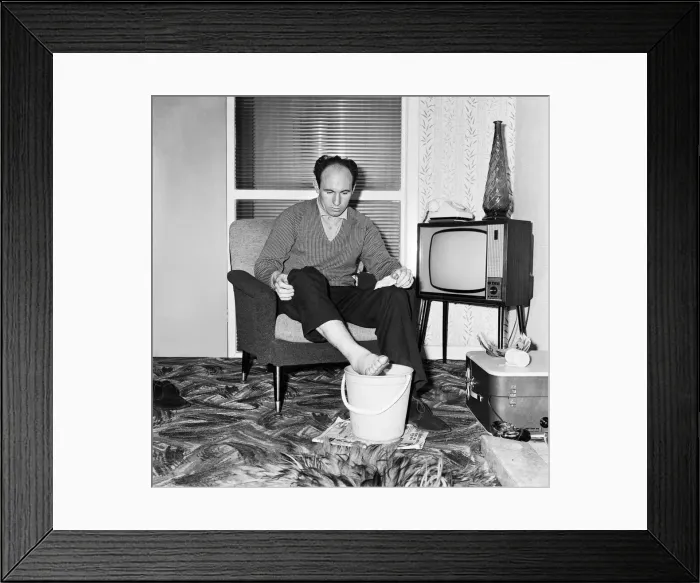 Framed Print : Liverpool and England international footballe Jimmy Melia soothes his injured foot in a Framed Print : Liverpool and England international footballe Jimmy Melia soothes his injured foot in a