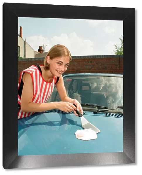A girl frying an egg on a car bonnet during the 1995 heatwave. 1st August 1995