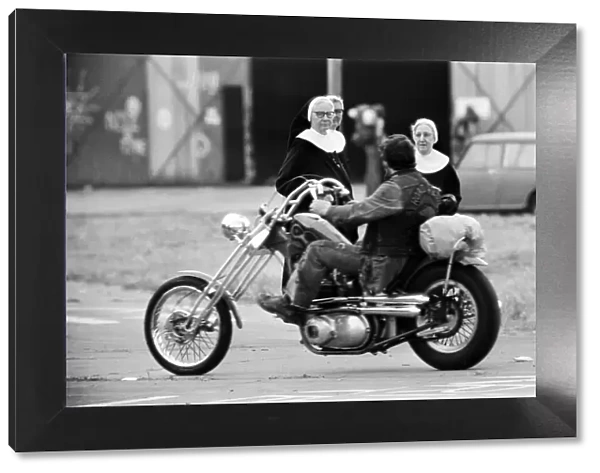 Nuns looking at a man on a motorbike, Watchfield Pop festival