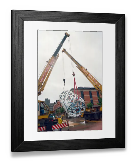 Framed Print : The sculpture Bottle of Notes is lifted off its low loader in the Central Framed Print : The sculpture Bottle of Notes is lifted off its low loader in the Central
