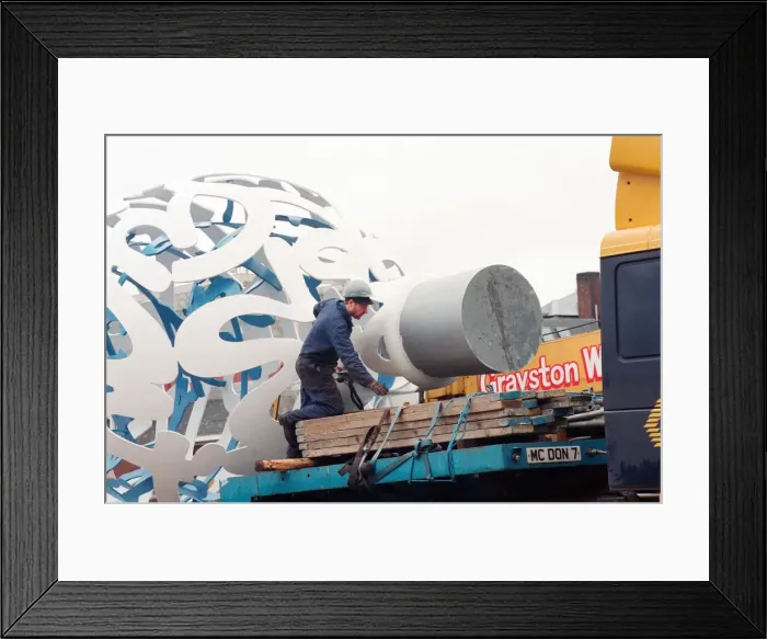 Framed Print : The sculpture Bottle of Notes is lifted off its low loader in the Central