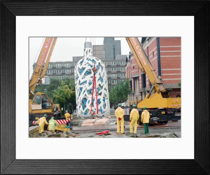 Framed Print : The sculpture Bottle of Notes is lifted off its low loader in the Central Framed Print : The sculpture Bottle of Notes is lifted off its low loader in the Central