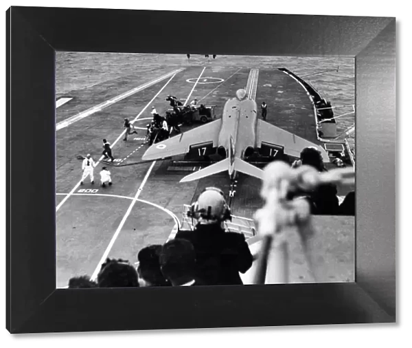 A supermarine Scimitar is manoeuvred on to the starboard catapult ready for take off