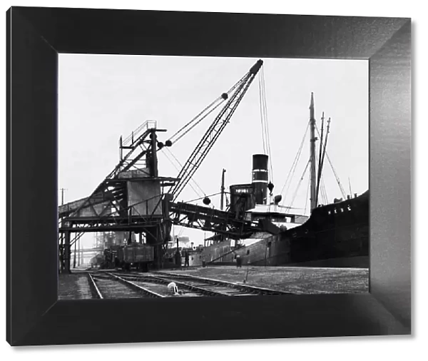 A ship loading anthracite coal by conveyor at the Swansea docks. Circa January 1937