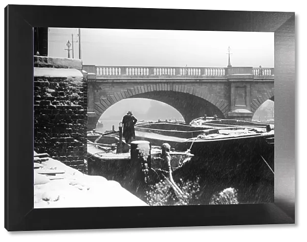 A lighterman secures his barges below Kingston Bridge on the River Thames