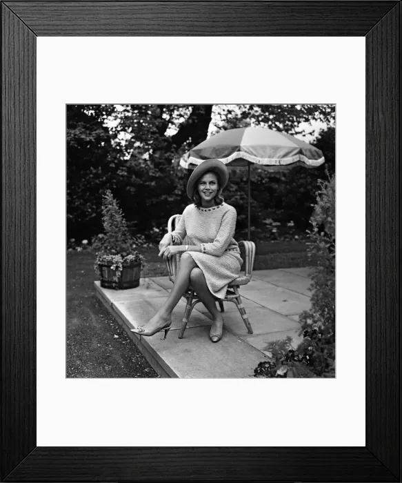 Framed Print : Actress Honor Blackman relaxes in her garden party outfit during the filming of