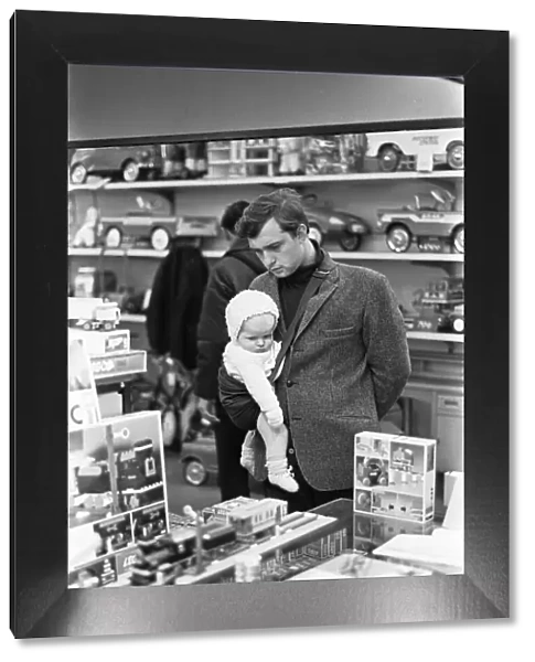 Father and baby son browse the latest Lego sets in the toy department of Heelas