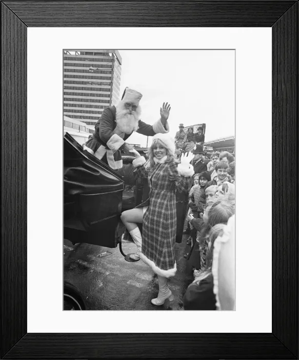 Framed Print : Father Christmas seen here helping his assistant into a horse drawn carriage after Framed Print : Father Christmas seen here helping his assistant into a horse drawn carriage after