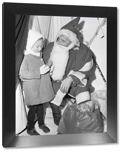 A small girl receives a present from Father Christmas at Woodley 18th November 1966