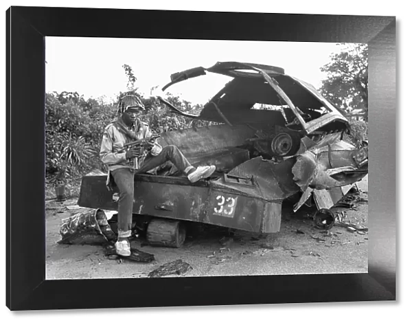 A Biafran soldier seen here sitting on a destroyed Nigerian army armoured personnel