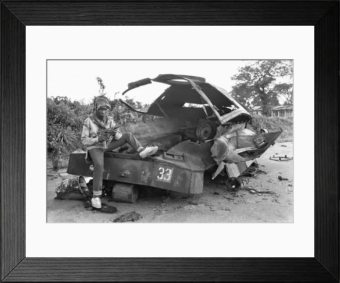 Framed Print : A Biafran soldier seen here sitting on a destroyed Nigerian army armoured personnel Framed Print : A Biafran soldier seen here sitting on a destroyed Nigerian army armoured personnel