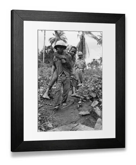 Framed Print : A Biafran soldier seen here carrying an injured comrade during the Biafra conflict