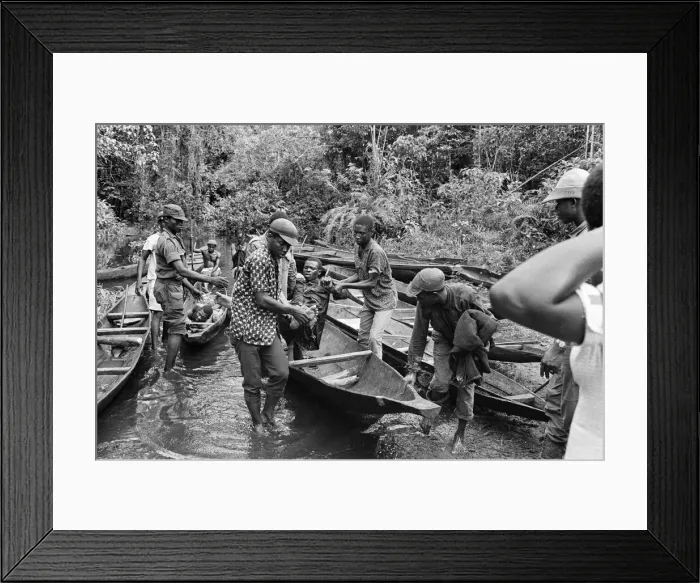 Framed Print : Biafran soldiers and helpers seen here carrying an injured comrade onto a canoe to cross Framed Print : Biafran soldiers and helpers seen here carrying an injured comrade onto a canoe to cross