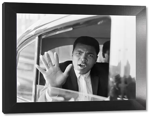Cassius Clay aka (Muhammad Ali) waves from his car after his arrival in London