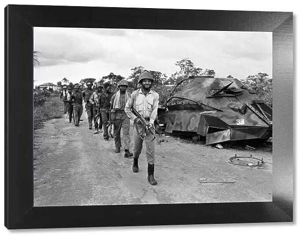 Biafran soldiers seen here marching past a destroyed Nigerian army armoured personnel