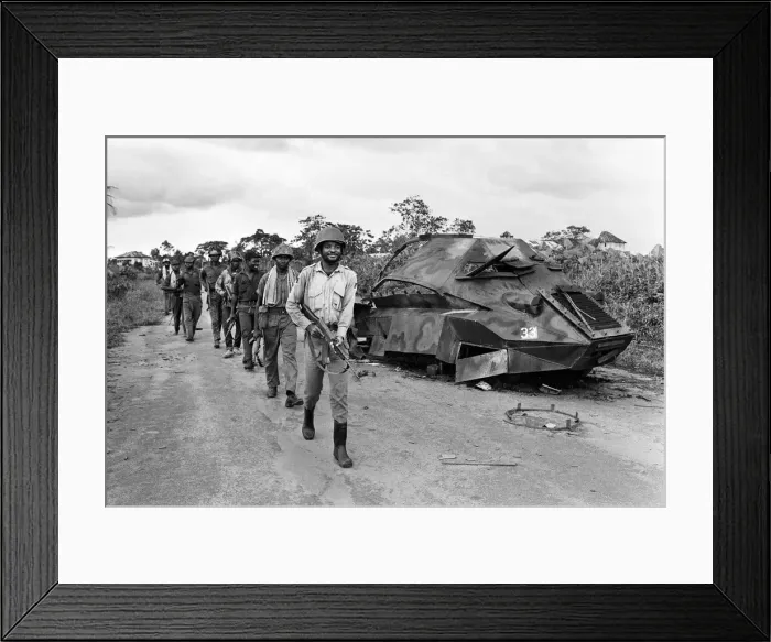 Framed Print : Biafran soldiers seen here marching past a destroyed Nigerian army armoured personnel Framed Print : Biafran soldiers seen here marching past a destroyed Nigerian army armoured personnel