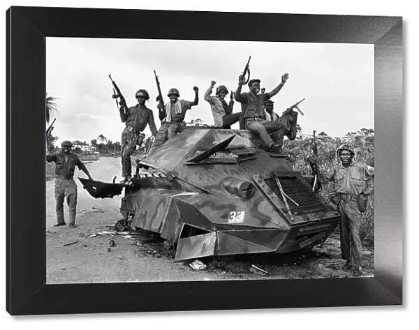 Joyous Biafran soldiers seen here cheering with guns in the air as they sit atop a