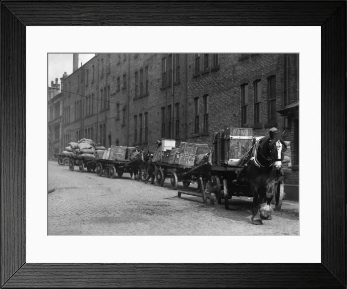Framed Print : Heavy horses with their carts wait to offload their deliveries in this un-named Framed Print : Heavy horses with their carts wait to offload their deliveries in this un-named