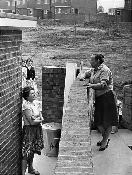 Neighbours Mrs Moria Foster (left) and Mrs Phillis Tanner chat over the garden wall