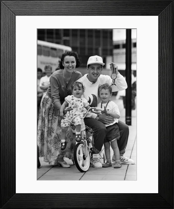 Framed Print : British cyclist Chris Boardman poses with his family on arrival at Manchester airport as Framed Print : British cyclist Chris Boardman poses with his family on arrival at Manchester airport as