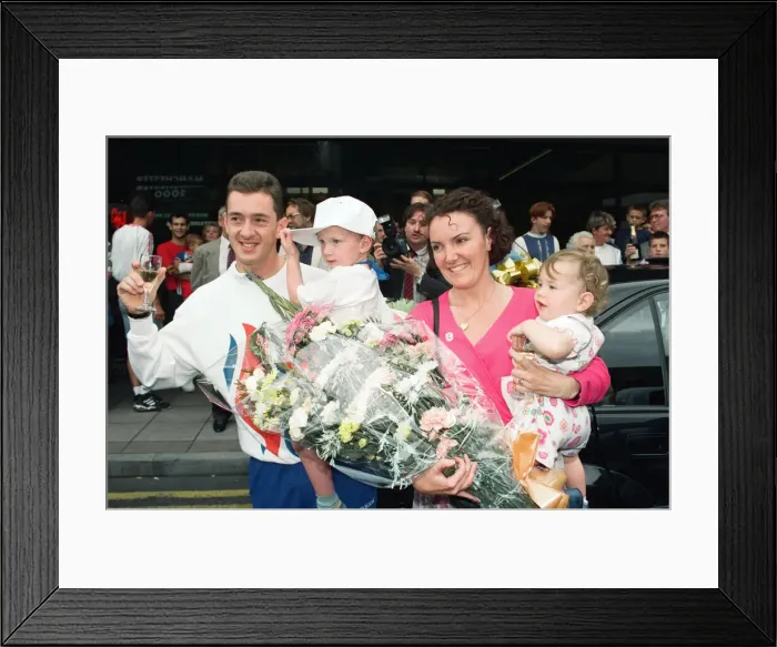 Framed Print : British cyclist Chris Boardman poses with his family on arrival at Manchester airport as Framed Print : British cyclist Chris Boardman poses with his family on arrival at Manchester airport as