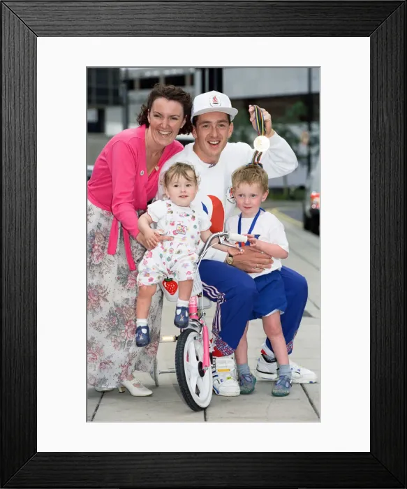 Framed Print : British cyclist Chris Boardman poses with his family on arrival at Manchester airport as Framed Print : British cyclist Chris Boardman poses with his family on arrival at Manchester airport as