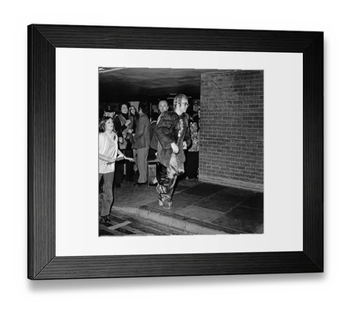Framed Print : Elton John arrives at Heathrow Airport, and has to run from the crowds of fans who are Framed Print : Elton John arrives at Heathrow Airport, and has to run from the crowds of fans who are