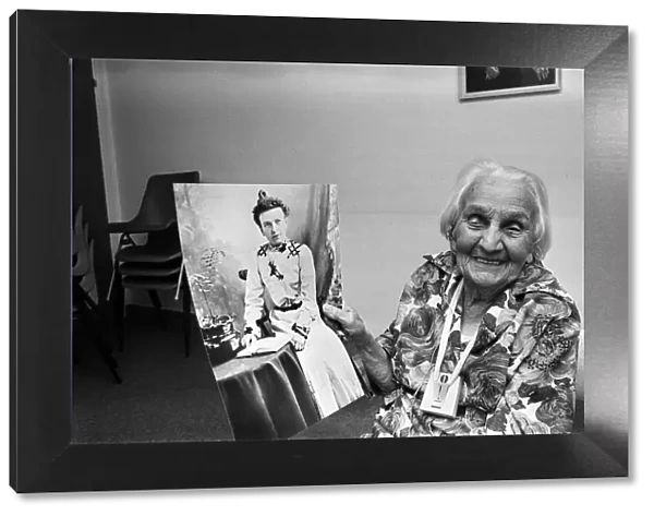 Kate Willison celebrates her 100th birthday. She is holding a picture of herself in her