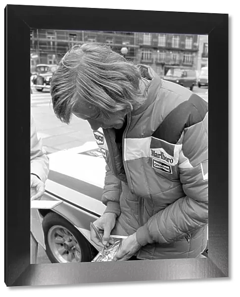 Motor Racing Driver James Hunt signs his autograph on a photograph of himself