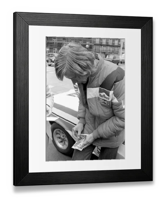 Framed Print : Motor Racing Driver James Hunt signs his autograph on a photograph of himself