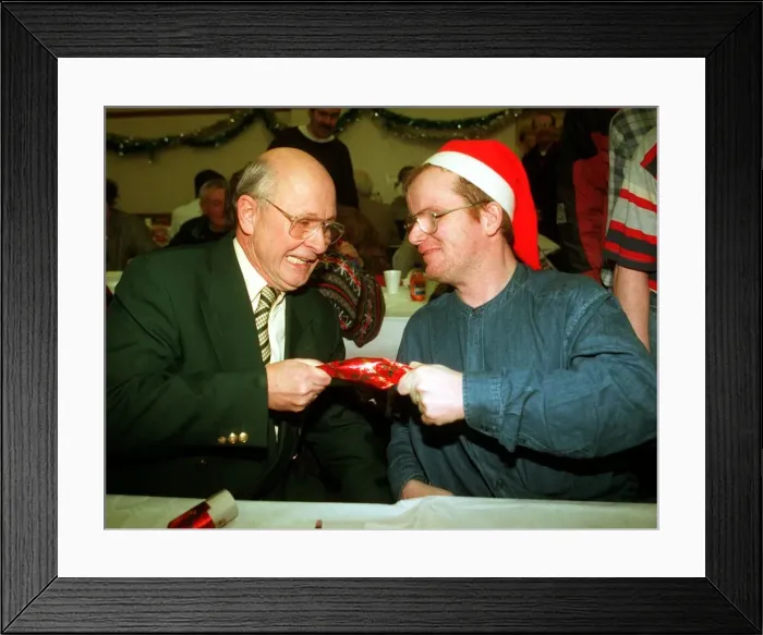 Framed Print : Fergus McCann pulls a cracker with Craig who Aattended a lunch for the homeless at St