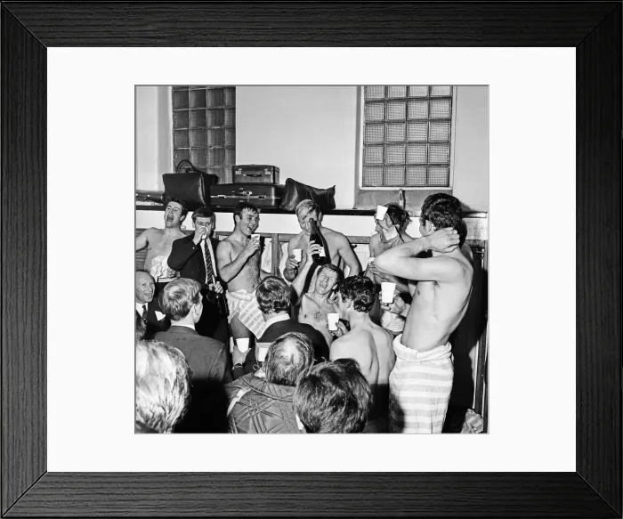 Framed Print : Manchester City players celebrate with champagne in the dressing room after sealing Framed Print : Manchester City players celebrate with champagne in the dressing room after sealing