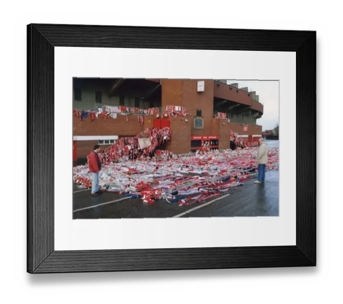 Framed Print : Manchester United fans bow their heads in respect as they observe collections of scarves Framed Print : Manchester United fans bow their heads in respect as they observe collections of scarves