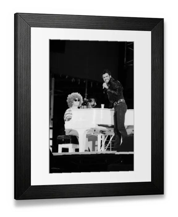 Framed Print : George Michael and Elton John, dressed as a clown, performing at the Wham
