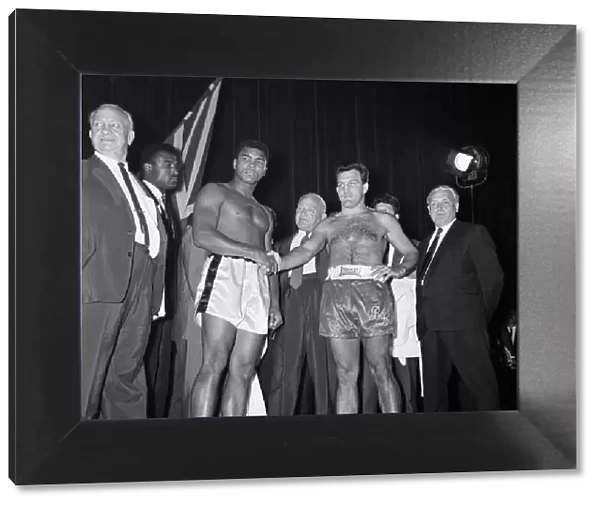 Muhammad Ali (left) and Brian London shake hands at the weigh-in ahead of their