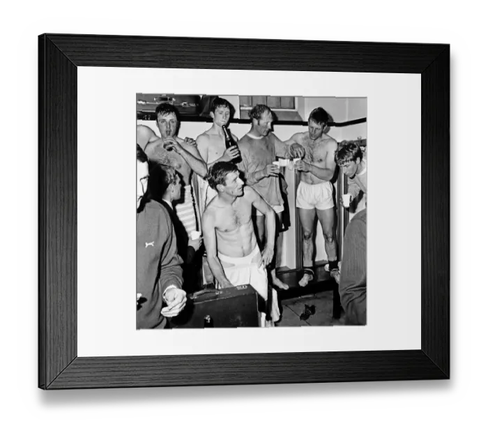 Framed Print : Manchester City players celebrate with champagne in the dressing room after sealing