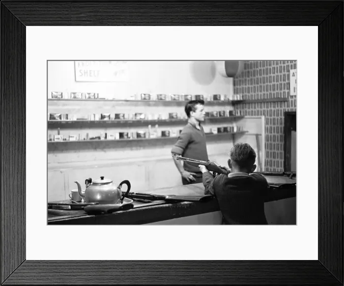 Framed Print : A young boy tries his luck on the rifle range stall at the end of Southend pier Framed Print : A young boy tries his luck on the rifle range stall at the end of Southend pier