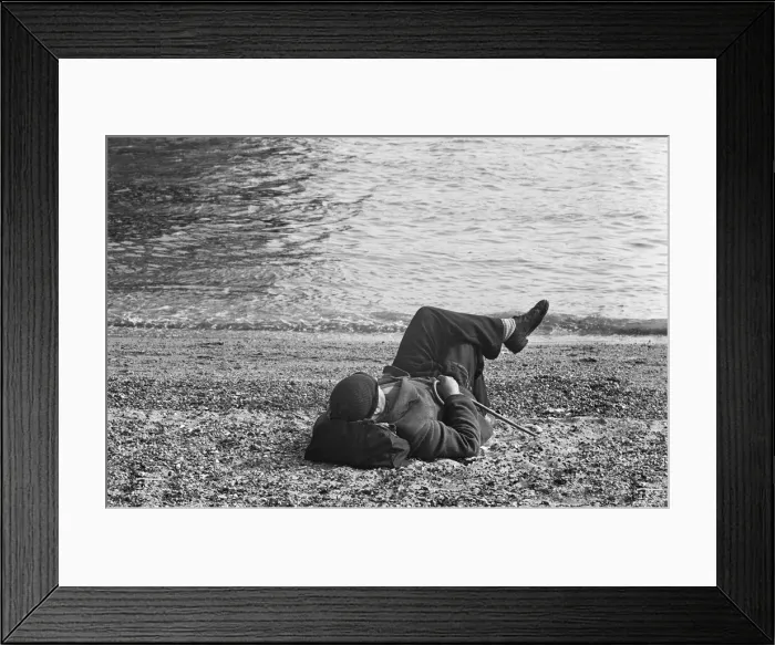 Framed Print : A day-tripper from Londons East End, relaxes in the summer sunshine on the beach Framed Print : A day-tripper from Londons East End, relaxes in the summer sunshine on the beach