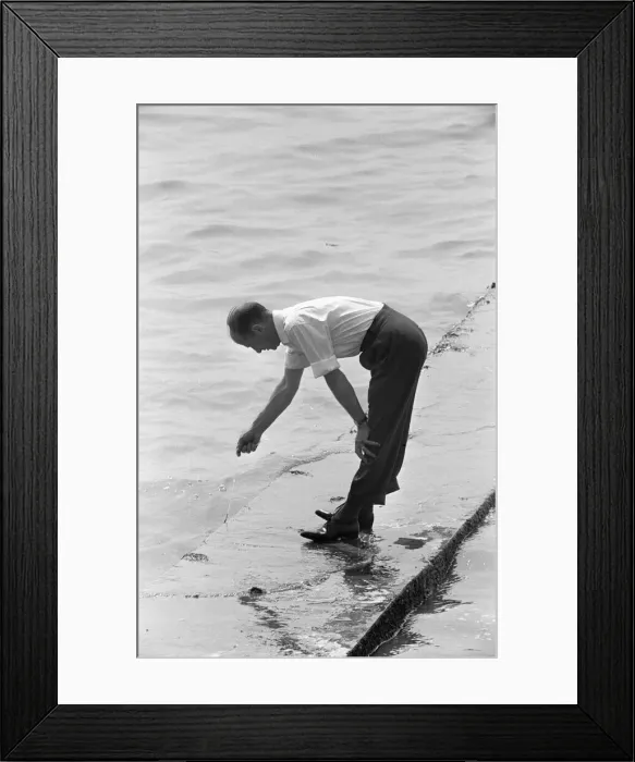 Framed Print : Dad is left holding the line, whilst trying to keep his feet dry during a day trip Framed Print : Dad is left holding the line, whilst trying to keep his feet dry during a day trip