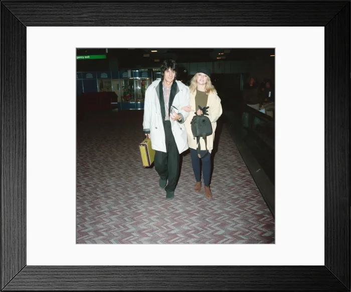 Framed Print : Ronnie Wood and his wife Jo at Heathrow Airport. 28th February 1991 Framed Print : Ronnie Wood and his wife Jo at Heathrow Airport. 28th February 1991
