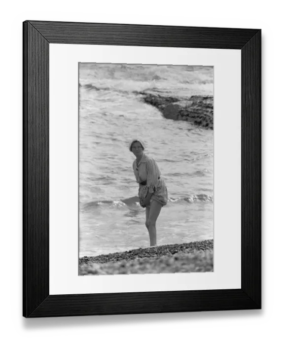 Framed Print : Holiday scenes at Brighton Elderly women paddling on the beach holding her skirt