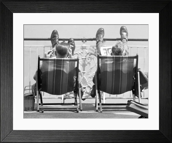 Framed Print : Holiday scenes at Brighton Two holidaymakers put their feet up on Brighton Framed Print : Holiday scenes at Brighton Two holidaymakers put their feet up on Brighton