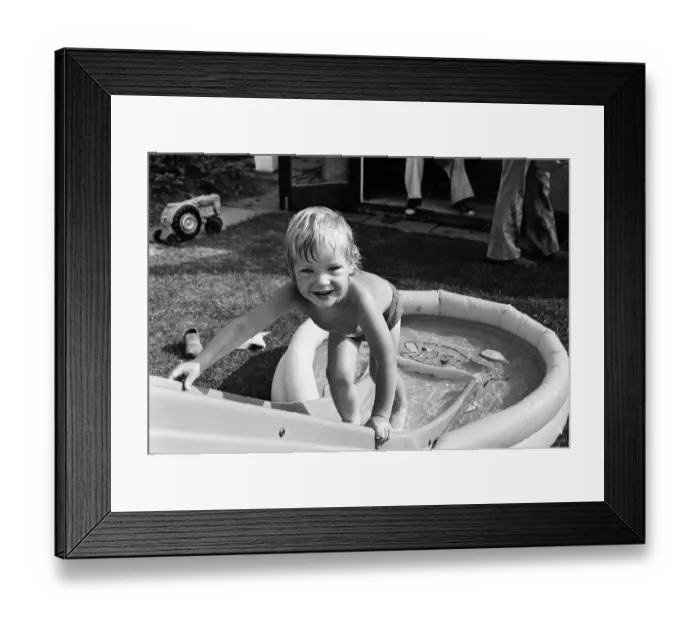 Framed Print : Mark Gordon cools off from the summer sun in his paddling pool. 28th June 1976