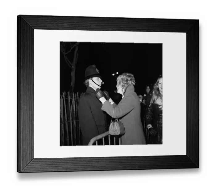 Framed Print : A woman kisses a policemen to celebrate New Year in Albert Square, Manchester, England Framed Print : A woman kisses a policemen to celebrate New Year in Albert Square, Manchester, England