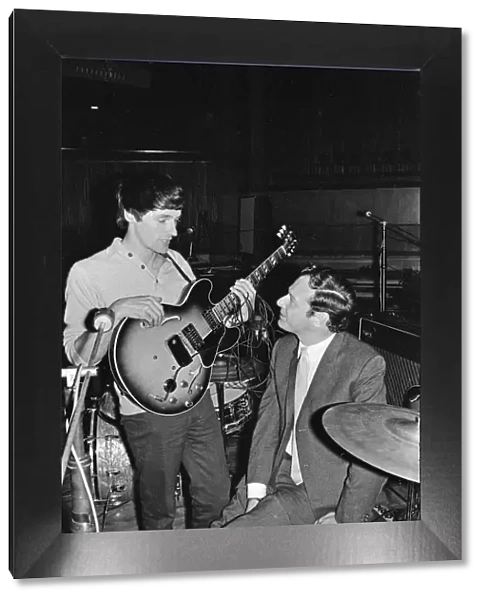 Brian Epstein (right) talks to a guitarist from one of the British bands appearing