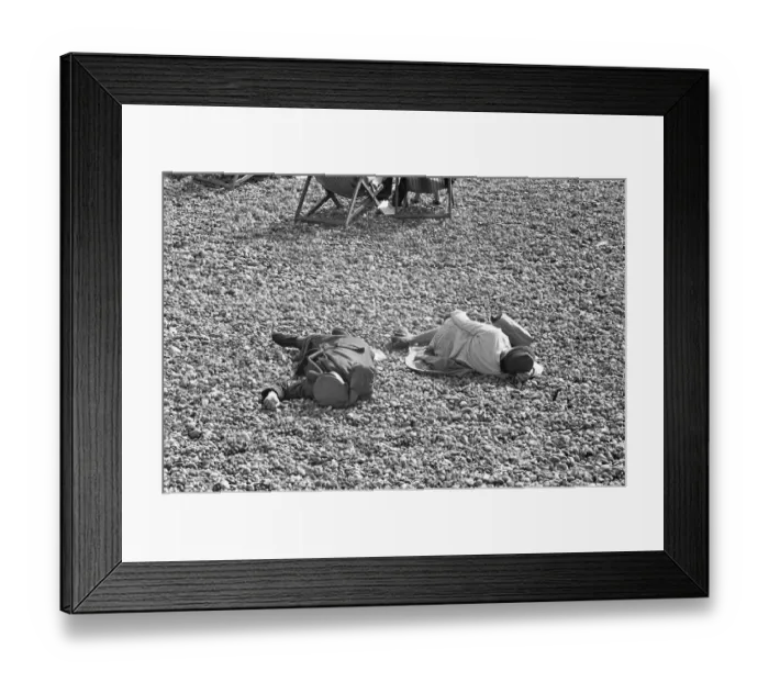 Framed Print : Holiday scenes at Brighton. Two elderly holidaymakers sleeping on the beach after