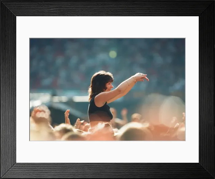 Framed Print : A lady aloft and enjoying the day, part of the huge audience watch American Rock Group