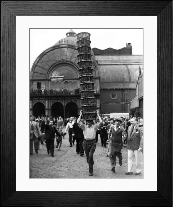 Framed Print : Porters from Covent Garden Flower and Vegetable market race with baskets stacked on their Framed Print : Porters from Covent Garden Flower and Vegetable market race with baskets stacked on their