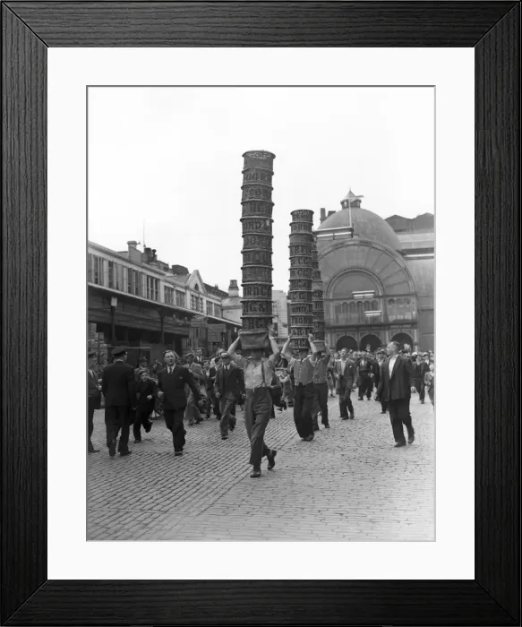 Framed Print : Porters from Covent Garden Flower and Vegetable market race with baskets stacked on their Framed Print : Porters from Covent Garden Flower and Vegetable market race with baskets stacked on their