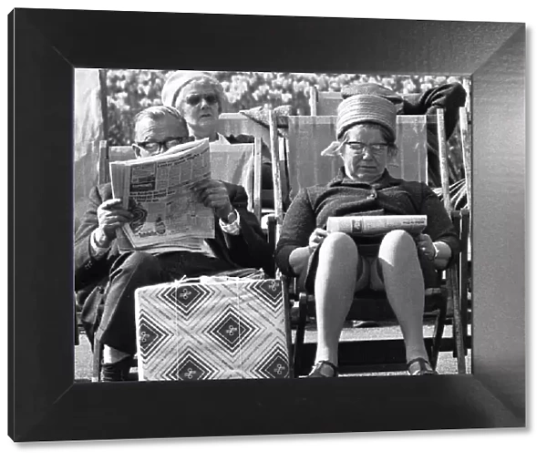 Pensioners reading the newspaper whilst enjoying the afternoon sun in Embankment Gardens